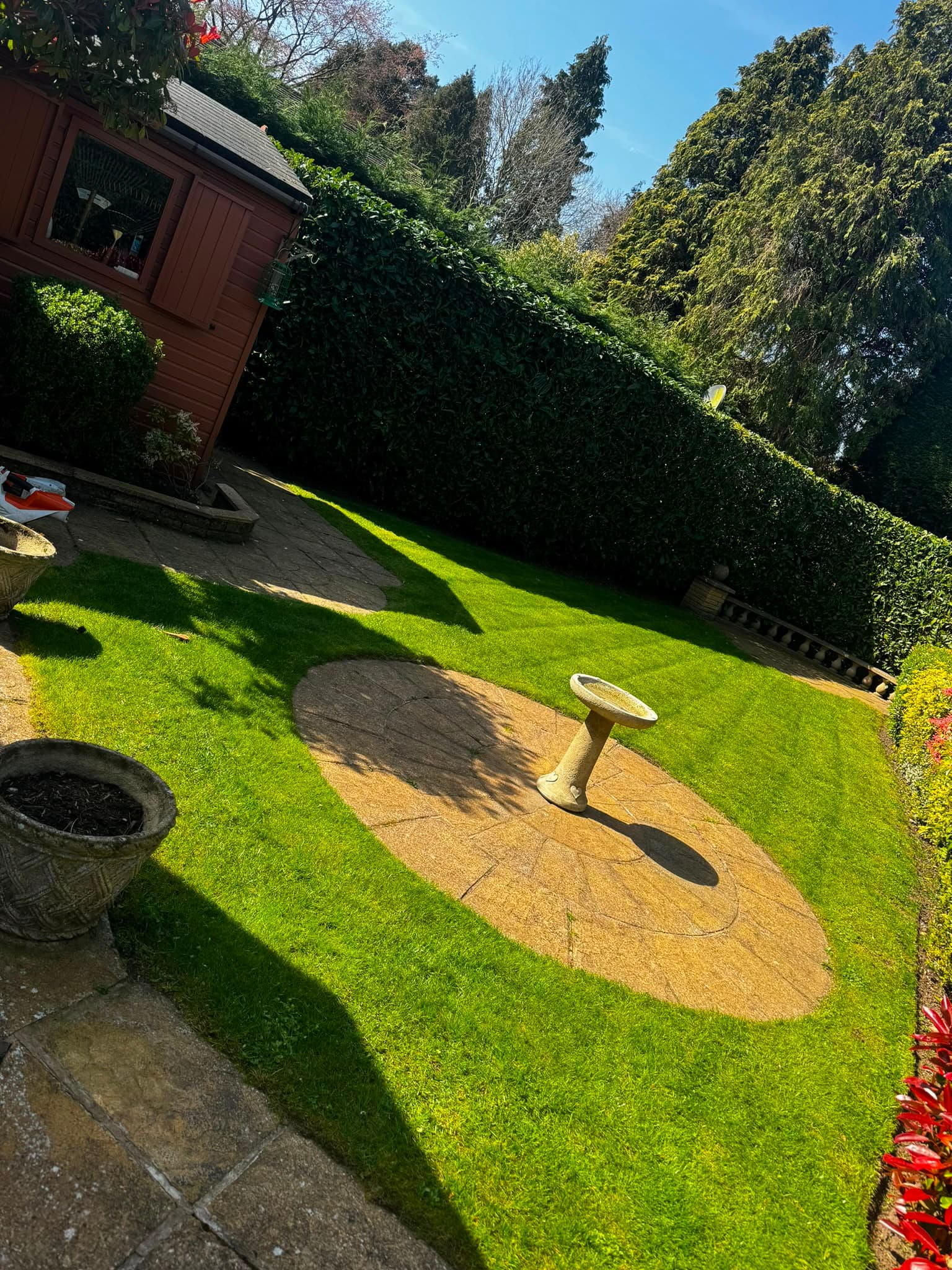 A mown lawn, trimmed hedge and swept paving in a Sutton Coldfield garden